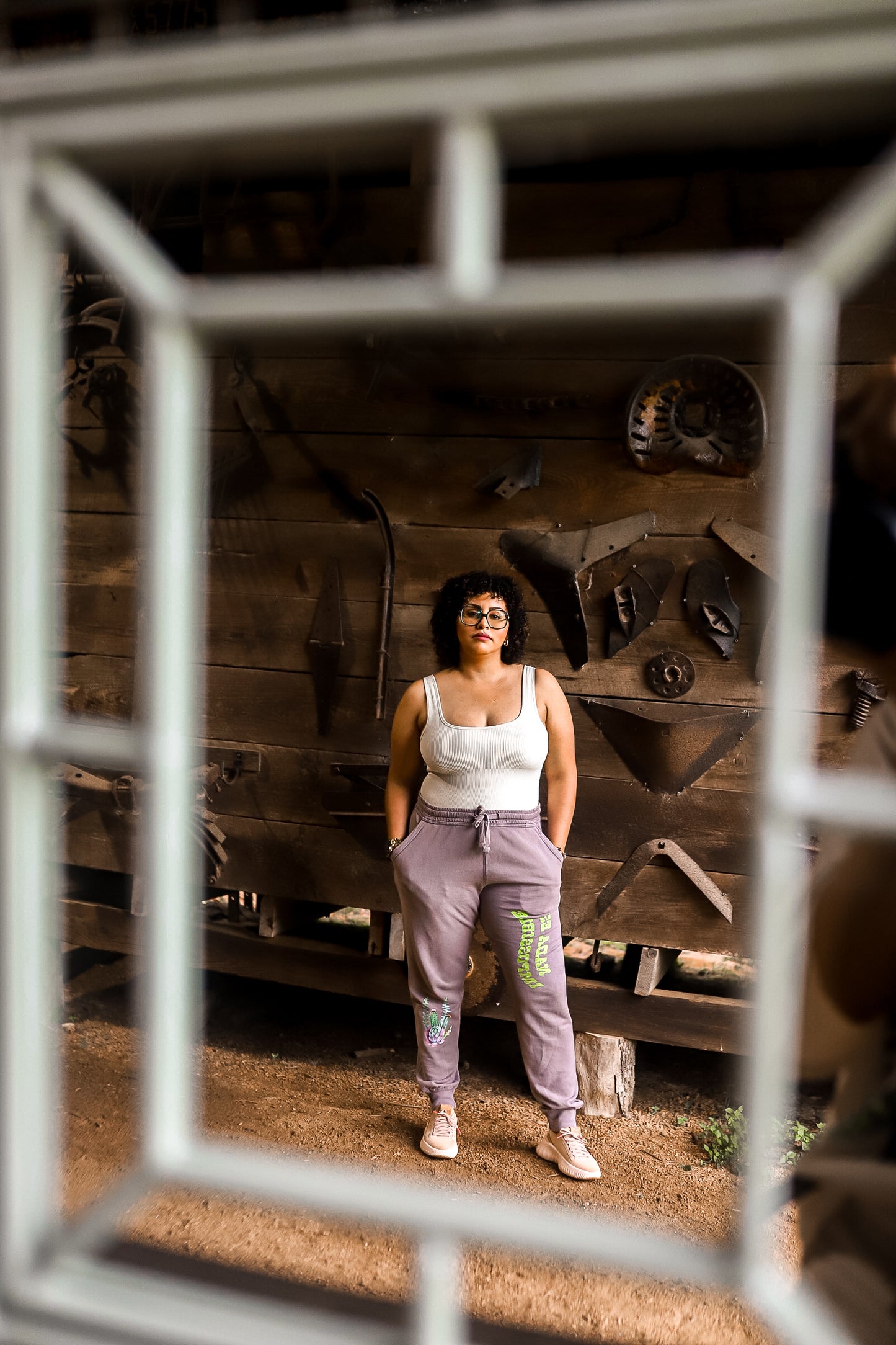 a reflection of a women wearing joggers with a tank top 