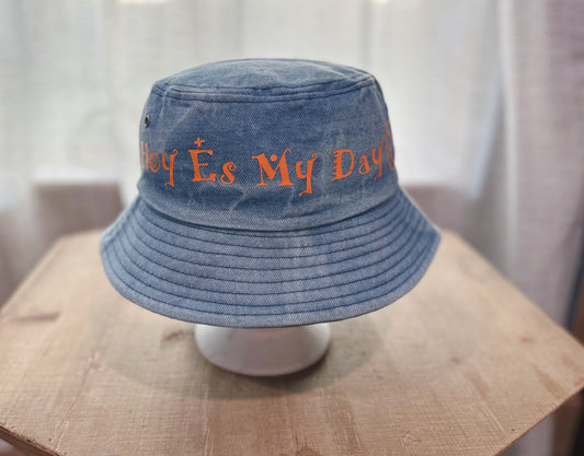 Jean Bucket Hat With Orange Text Saying " Hoy Es My Day ". 