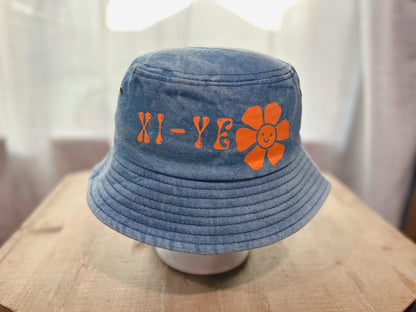 Jean Bucket Hat With Xi-Ye Branding With A Happy Face Flower.