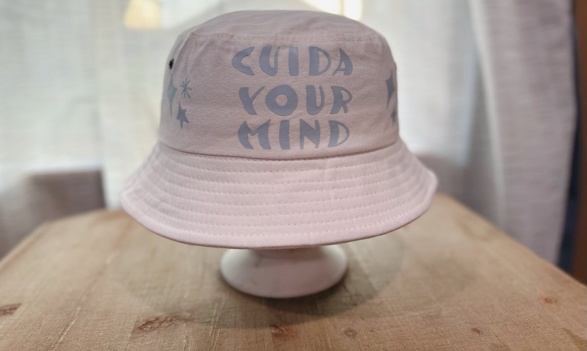 White Bucket Hat With Light Blue Saying " Cuida Your Mind". 