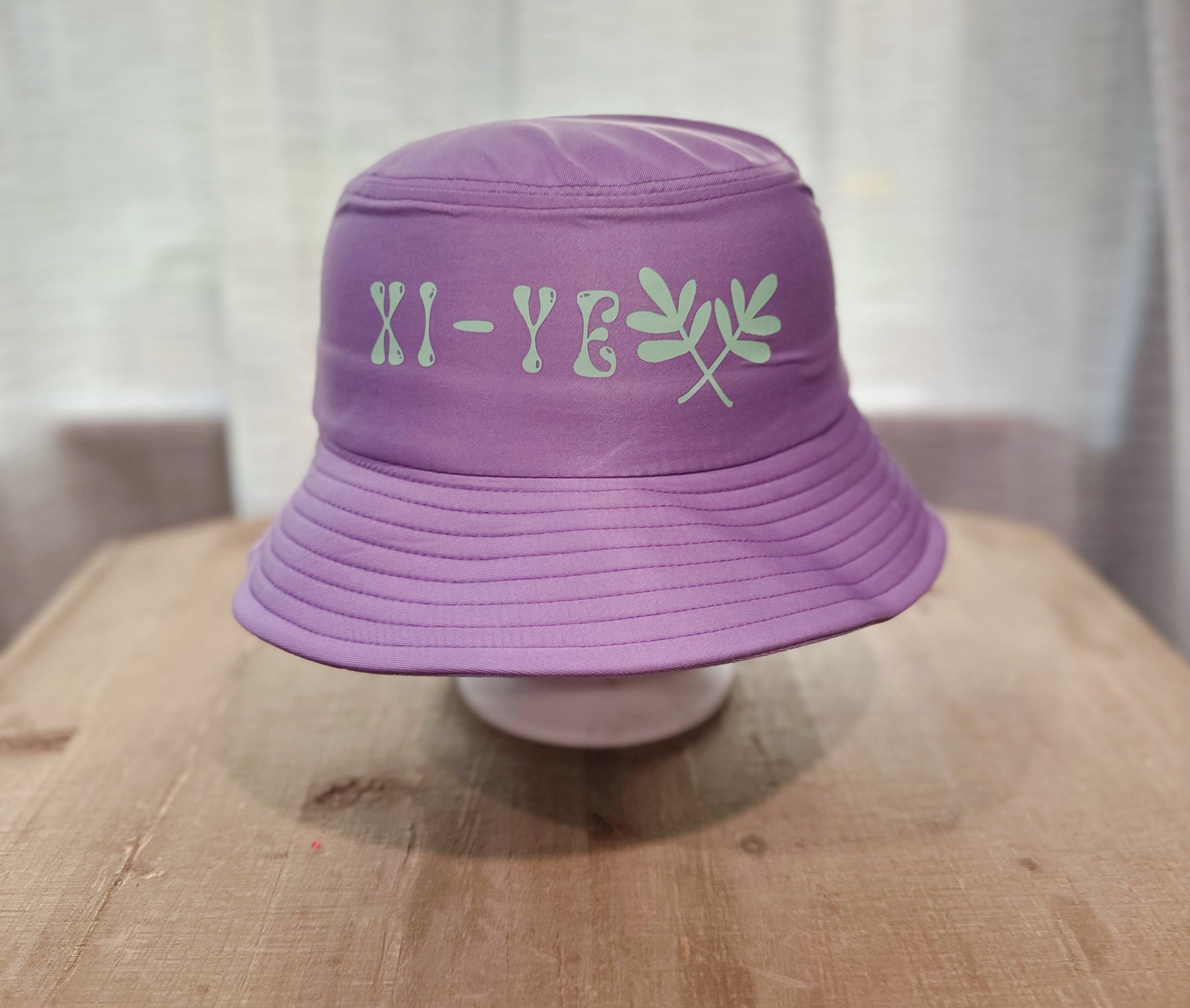 Purple Bucket Hat With Xi-Ye Branding. 